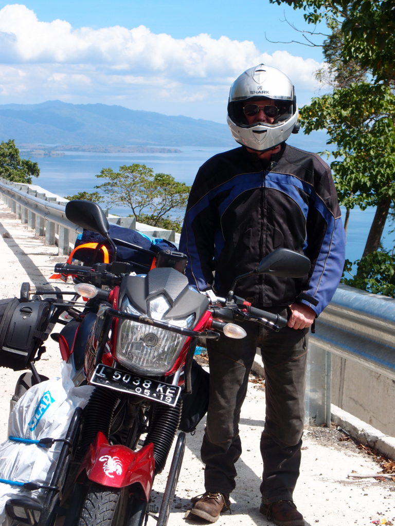 motorcycle and rider stopped alongside the highway in Sumbawa